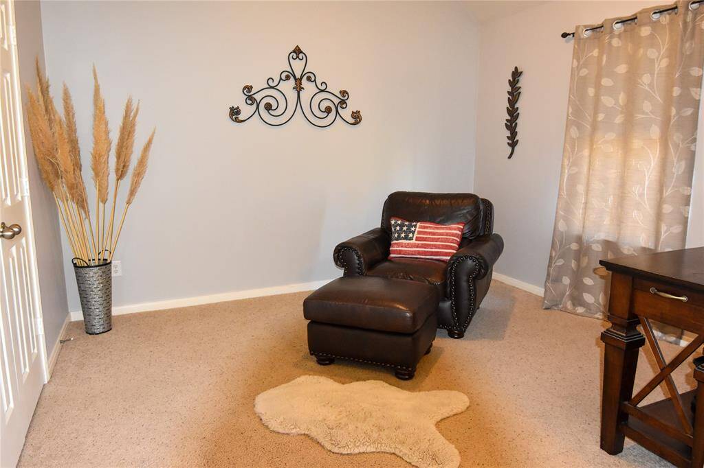 Dedicated sitting area offers a quiet space to unwind. Whether used for a cozy reading nook, a vanity setup, or simply a place to relax after a long day, this added luxury enhances the spa-like atmosphere of the primary suite.