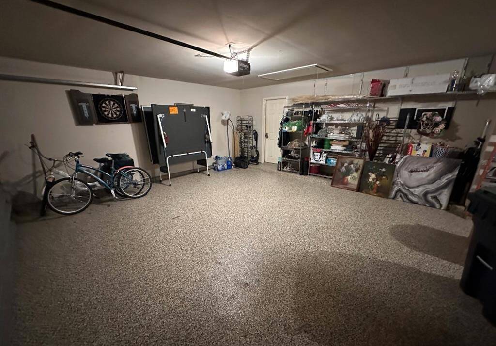 This spacious three-car garage features a durable epoxy-coated floor, offering a sleek, stain-resistant finish perfect for parking, storage, or a home workshop.