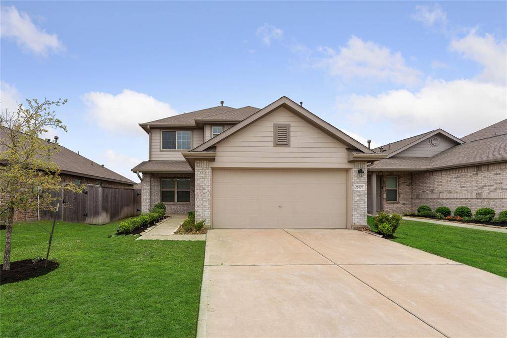 A lovely two-story house with a double garage. Check out the brick accents,  and a well-maintained lawn