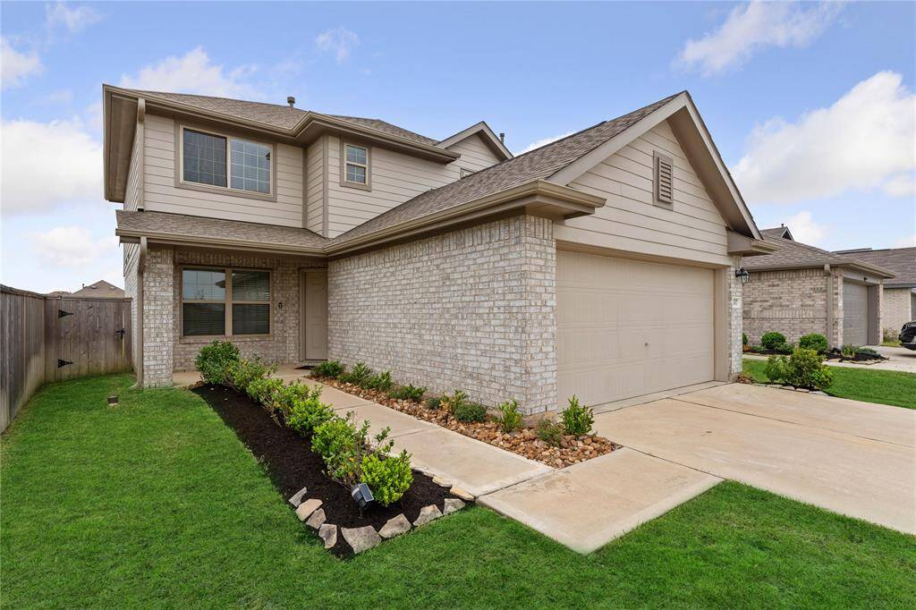 A lovely two-story house with a double garage. Check out the brick accents,  and a well-maintained lawn