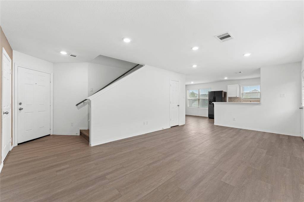 Open-concept living area with modern laminate flooring and recessed lighting.