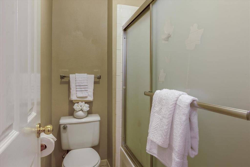 The guest bathroom features a private shower/tub combo with its own door for added privacy. A sliding glass door on the tub enhances both style and convenience.