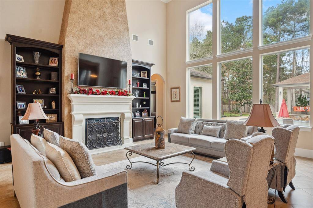 This grand space boasts a ceiling over 20 feet tall and has a wall of windows that extends throughout the back of the home.  Lovely, neutral tile though out and ever so spacious!