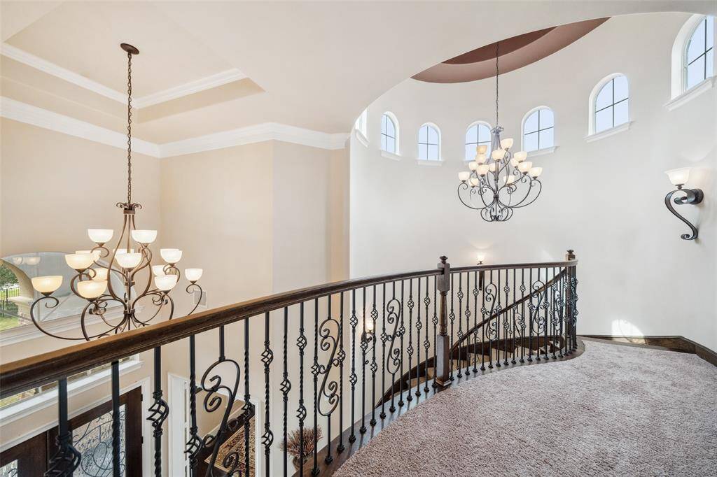 Up the elegant curved stairscase onto the walkway to the rest of the home upstairs.