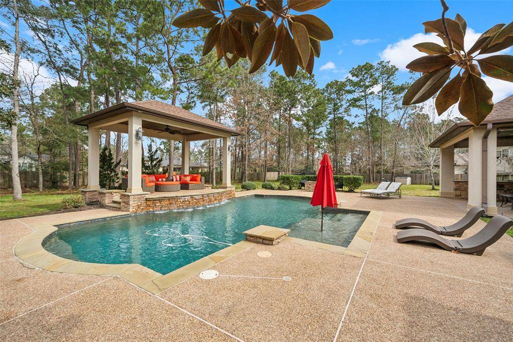 Another view of the lush backyard and let's not forget the waterfall on this beautiful pool!