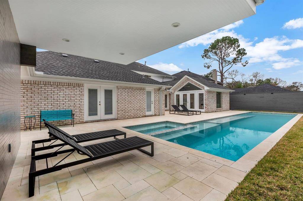Capturing the back of the home, the curated art room addition stands to the far right. An 11’ deep, 15’ wide cantilevered patio extends from the storage room and dual-purpose pool house, offering shaded comfort and a seamless transition to the expansive outdoor living space.