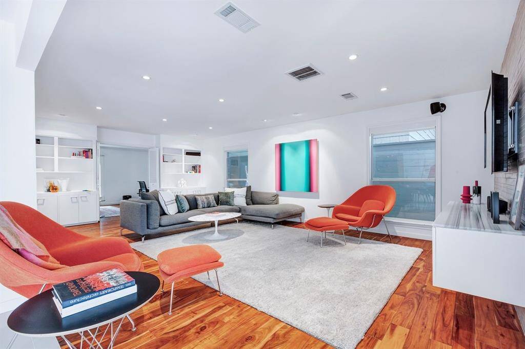 Commanding attention, this angle of the living room highlights the custom built-in cabinetry and shelving, offering both functionality and a sleek design element. The entertainment credenza, topped with beautifully Mink Marmara Equator marble, adds a refined touch, complementing the modern aesthetic of space.