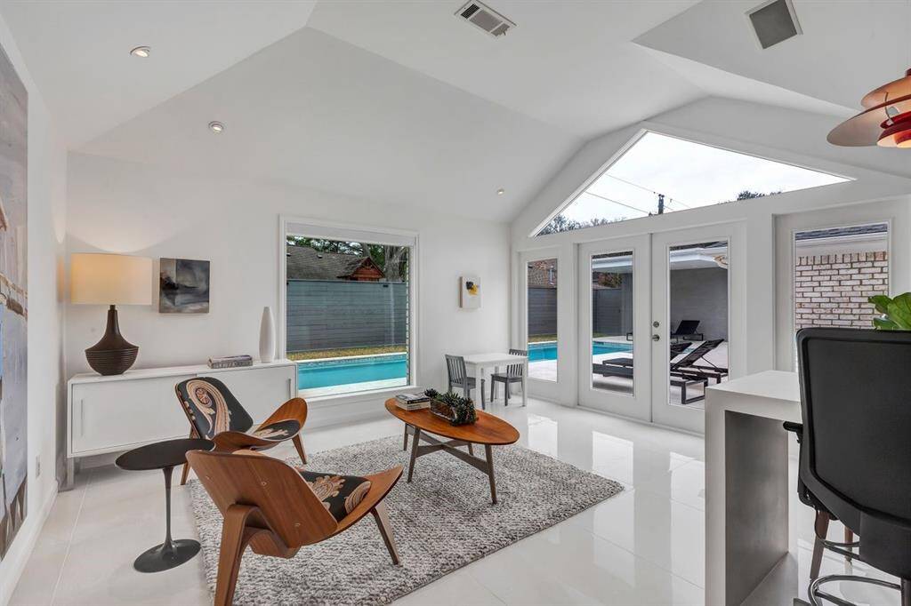 Envisioned as a creative sanctuary, the home was expanded in 2013 with an art room designed to inspire while seamlessly blending with the existing space. A vast wall of north-facing windows captures optimal natural light, providing an inspiring workspace throughout the day. French doors open to the back patio and pool area, creating a seamless indoor-outdoor connection. Dramatic vaulted ceilings enhance the sense of openness and light, elevating the room’s airy ambiance.