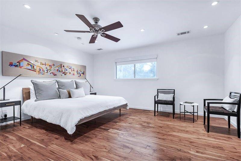 Reimagined for modern living, the primary suite blends warmth and functionality with rich acacia wood flooring and a sleek, contemporary aesthetic. A room-darkening window shade enhances privacy and ambiance, while the conveniently placedthermostat at the closet entry offers seamless climate control as one of three zones in the home.