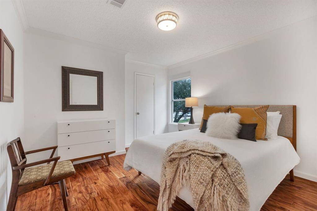 Among the three upstairs secondary bedrooms, this front-facing space is thoughtfully designed to maximize natural light, offering versatility as a guest suite, home office, or personal retreat. The walk-in closet, like all others upstairs, is fitted with commercial-grade level loop carpet, ensuring both durability and comfort.
