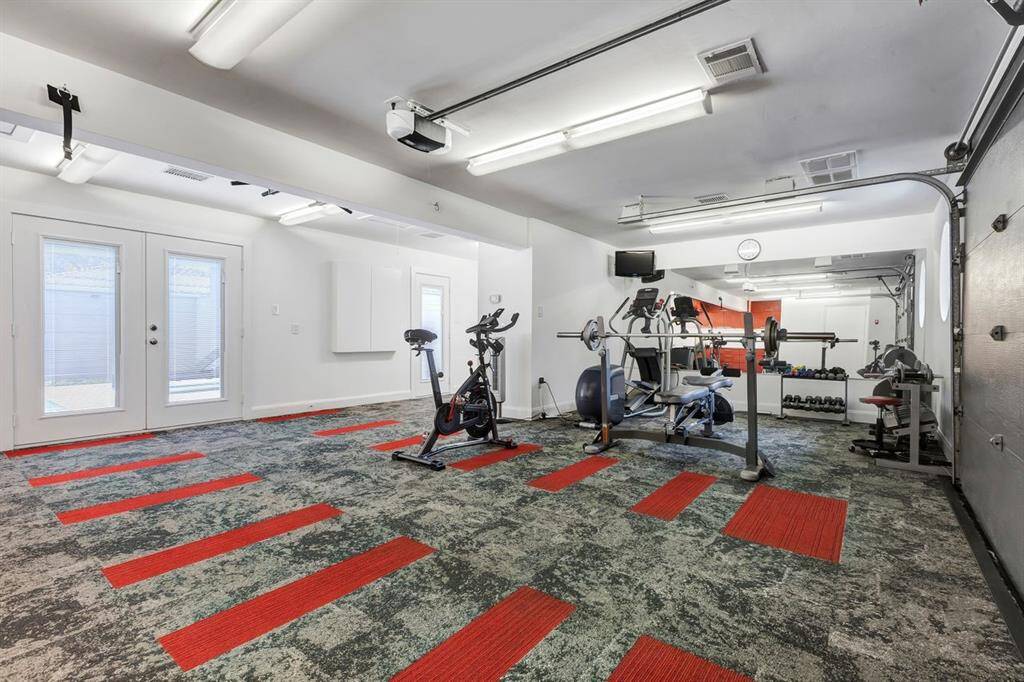 Designed for an active lifestyle, this fully insulated garage transforms into a high-end fitness space, featuring commercial-grade carpet tile flooring, floor-to-ceiling mirrors, and a mounted TV. A dedicated central heating and cooling system ensures year-round comfort, while French doors seamlessly connect to the pool area and backyard for effortless indoor-outdoor flow.