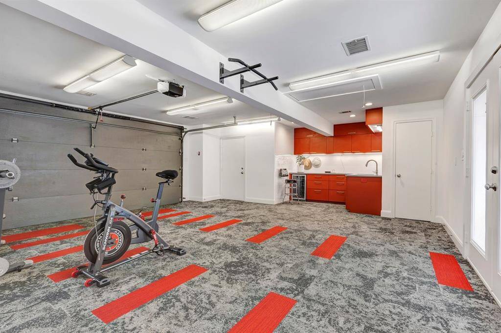 Spanning over 700 square feet, the 2004 garage expansion redefined this space, transforming it into a multifunctional area that blends utility, style, and comfort. For added convenience, the doorway to the right of the cabinetry leads to a discreetly enclosed half bath, complete with a patio door for seamless access to and from the pool area.