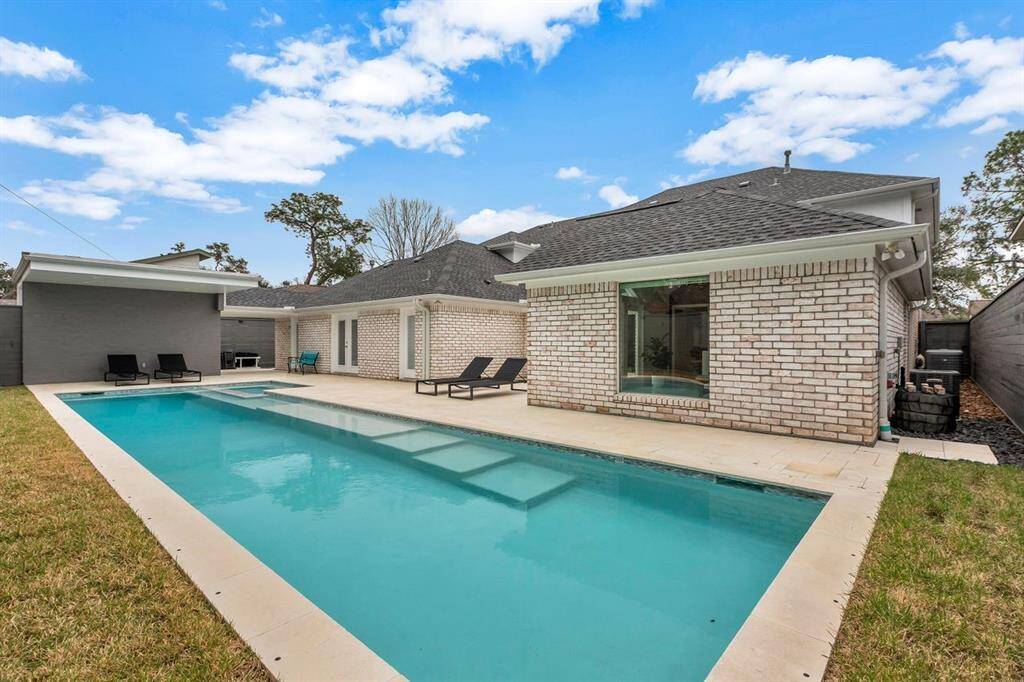 A serene backyard retreat, this outdoor space is designed for relaxation and effortless entertaining. The striking lap pool takes center stage, complemented by the modern pool house and storage area to the left. Clean lines and a minimalist aesthetic define the design, with a half bath conveniently located through the single door to enhance functionality for poolside gatherings.