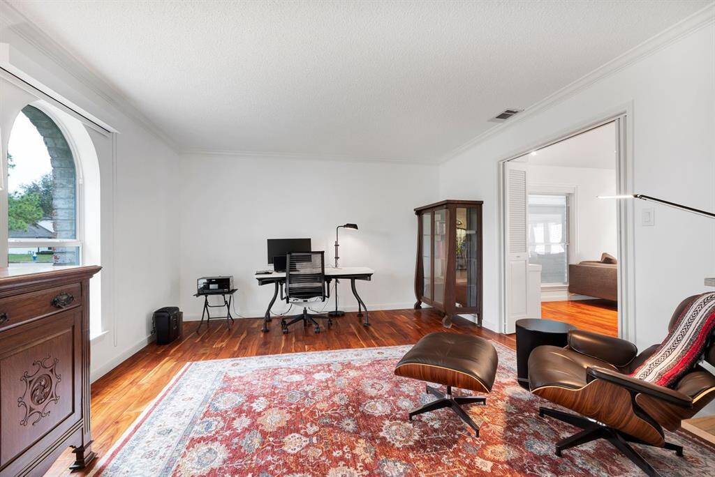 Bathed in natural light, the front-facing room is currently used as an home office and offers exceptional versatility. A large arched window enhances the space, while an open doorway connects to the main living area, and bi-fold doors provide privacy—making it ideal for a home office, study, or sitting room.
