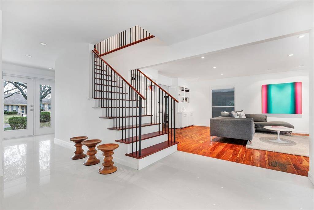 As you step through the front door, the home’s thoughtful design unfolds with seamless flow, leading effortlessly into the main living spaces. The striking staircase, with rich Brazilian Cherry wood treads and sleek wrought iron balusters, serves as an elegant focal point, while the upstairs hallway is subtly framed, maintaining an open yet refined connection throughout.