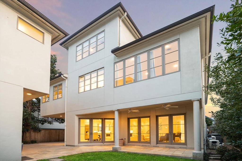 The rear view of the home with a large, covered patio.