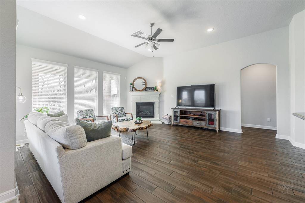 The family room boasts a wall of windows that flood the space with natural light, creating a bright and airy atmosphere. High angled ceilings and recessed lighting add to the room's sense of openness and elegance, making it the perfect place to relax and gather.