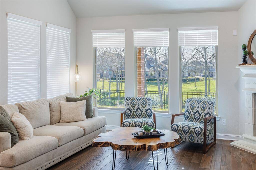 The spacious family room is the perfect place to gather with loved ones, featuring a high ceiling making this room light and airy, a cozy fireplace with mantel, and breathtaking views of the greenbelt out back. With an open sightline through the wrought iron fence, you can enjoy the scenic beauty right from your living space.