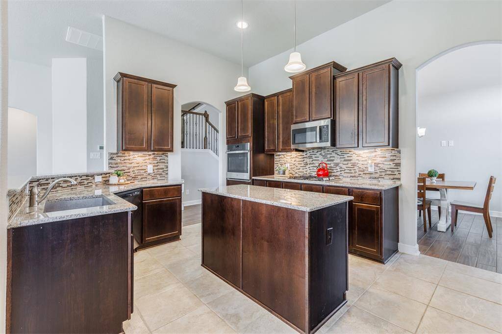 As you look across the designer kitchen, you'll see there's an abundance of gleaming granite counter space, providing ample room for meal preparation. Featuring a granite topped central island and counters, stainless steel appliances and rich cabinetry with undercabinet lighting with plenty of storage space.