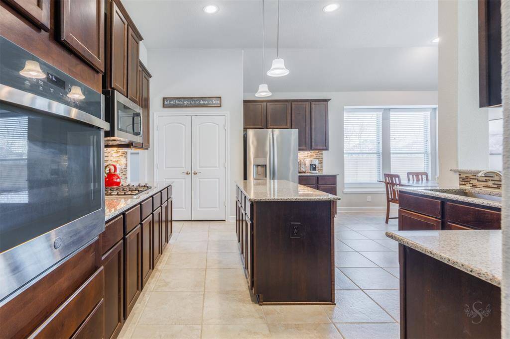 The designer kitchen provides an abundance of gleaming granite counter space and provides ample room for meal preparation. Featuring a granite topped central island and counters, stainless steel appliances and rich cabinetry with undercabinet lighting which provides plenty of storage space.