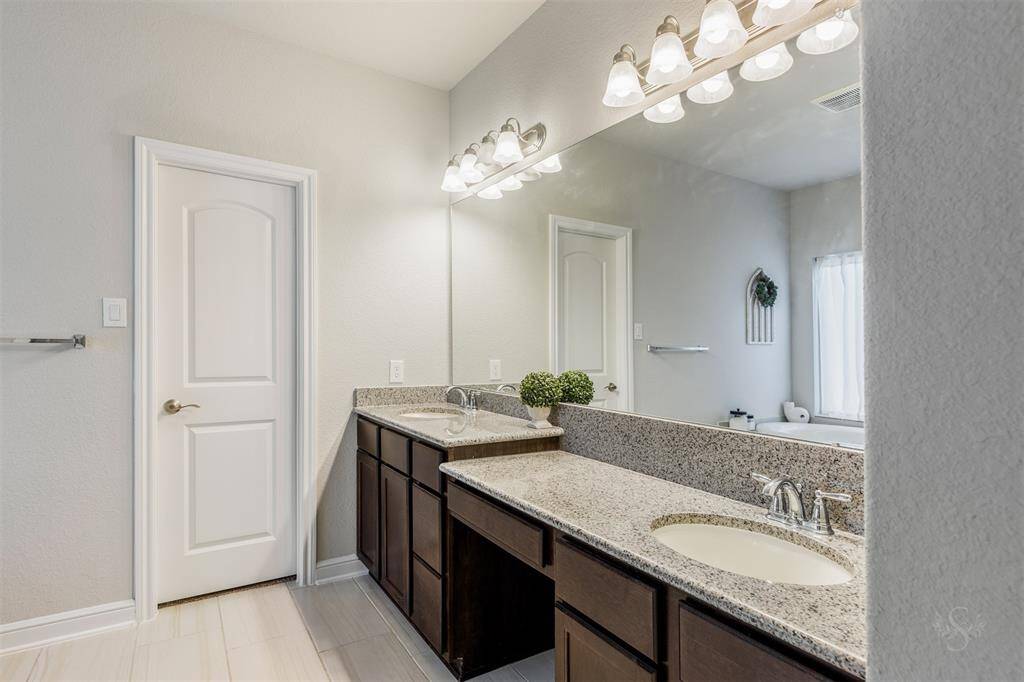 Step into this relaxing primary bath featuring an extended double sink granite vanity, make up vanity, garden tub and a large enclosed shower with tile surround!