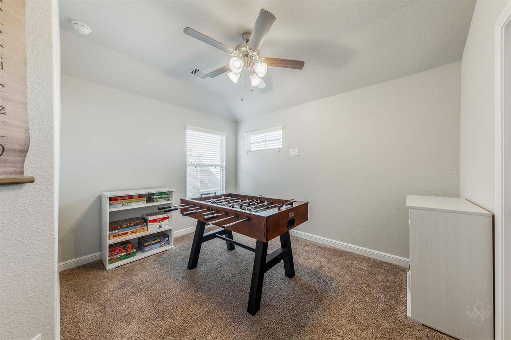 This secondary bedroom features a high angled ceiling, a window with blinds, carpet for comfort and provides plenty of room for a bed and your bedroom furnishings including a student desk.