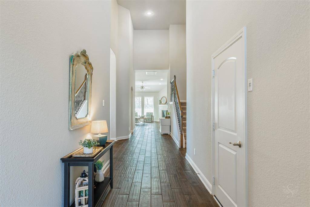 Guests will be welcomed into this charming entryway, showcasing elegant wood-look tile flooring, high ceilings and the perfect space to display your favorite artwork and décor!