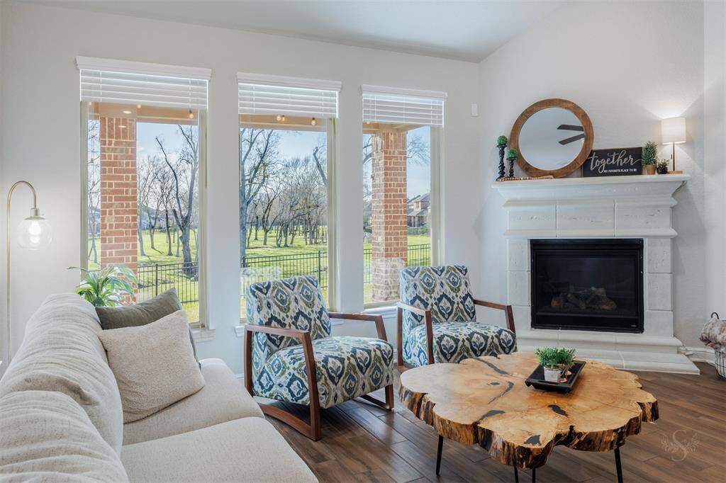 The spacious family room is the perfect place to gather with loved ones, featuring a high ceiling making this room light and airy, a cozy fireplace with mantel, and breathtaking views of the greenbelt out back. With an open sightline through the wrought iron fence, you can enjoy the scenic beauty right from your living space.
