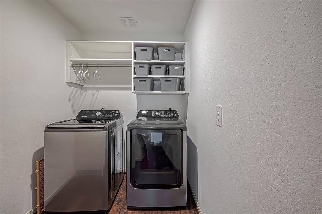 This photo shows the compact laundry room. Look at the overhead shelving, storage space, and small rod for hanging clothes. You will also find a large built-in cabinet for all your storge needs.