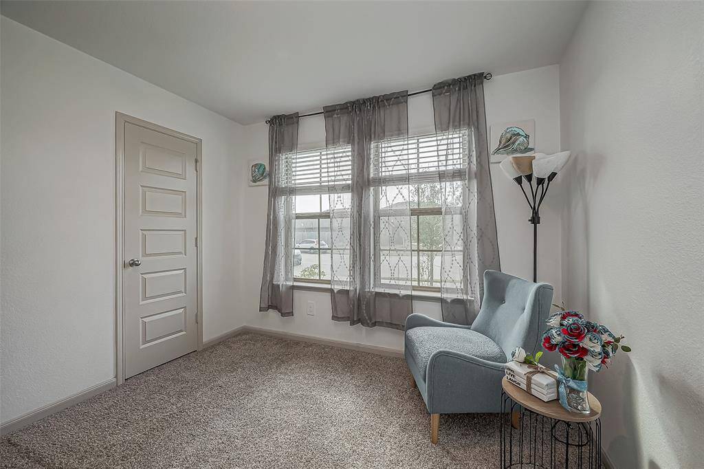 Another view of the secondary bedroom with a soft carpeted floor and ample natural light. The neutral color palette creates a welcoming atmosphere.