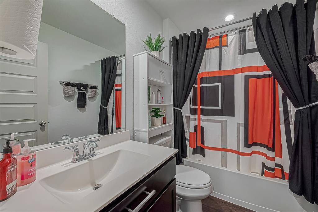 This bathroom features a modern design with a sleek vanity, large mirror, and contemporary faucet.