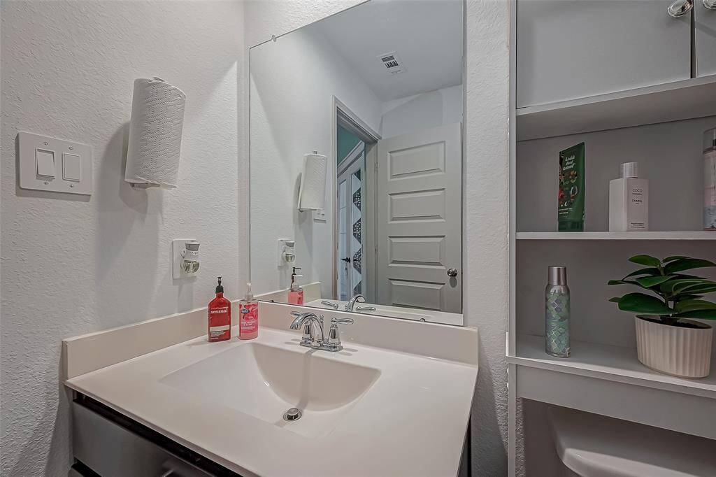 This bathroom features a modern sink with a sleek faucet and large mirror.