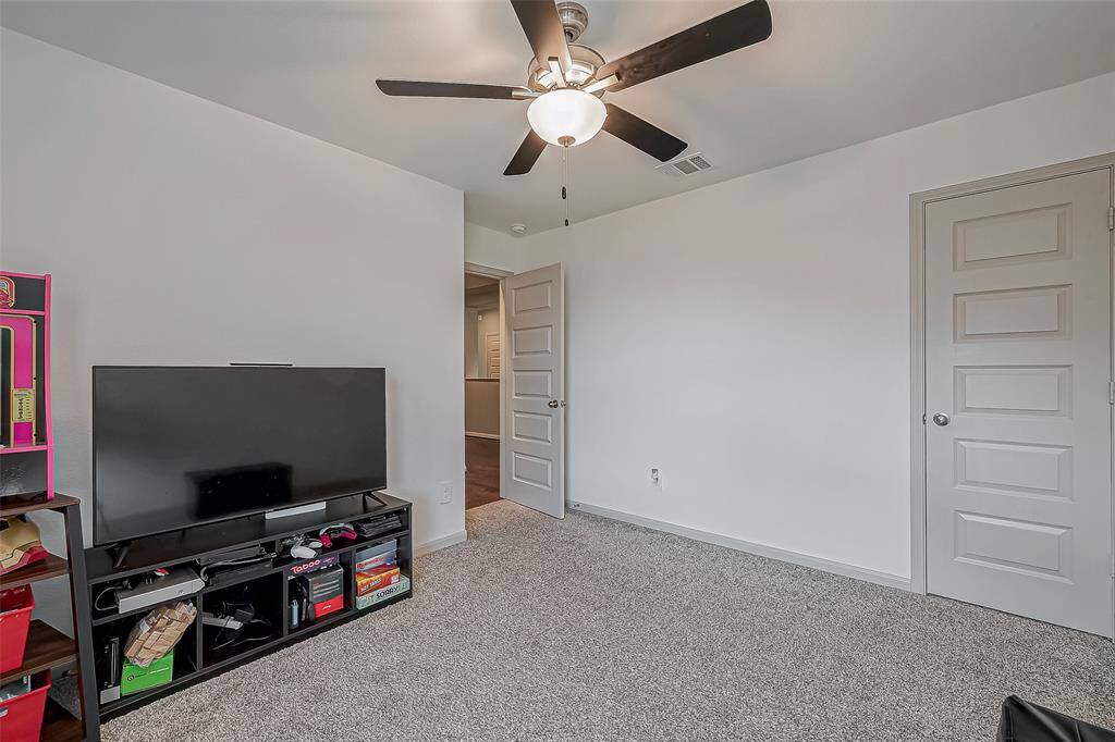 Another view of this secondary bedroom featuring neutral walls, soft carpet flooring, and a ceiling fan with a light.