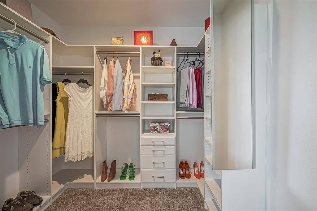 This photo showcases a spacious, well-organized walk-in closet with ample shelving and hanging space, ideal for efficient storage and accessibility.