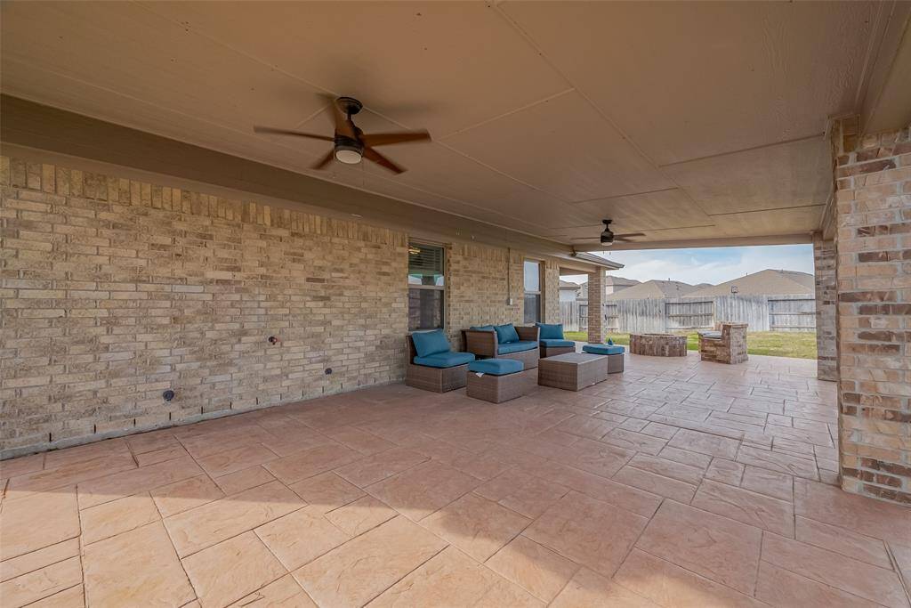 Another look at this fabulous, spacious, covered patio with a ceiling fan, perfect for outdoor relaxation.  Sit back and enjoy the view of the backyard, enclosed by a wooden fence.