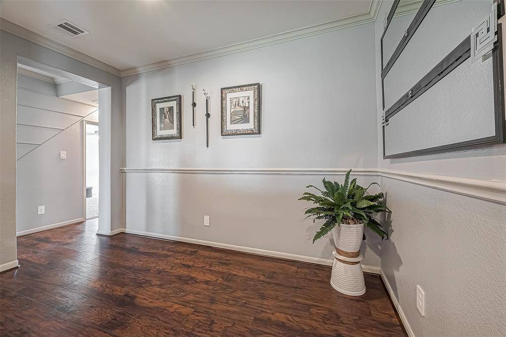 This photo shows the dining room with elegant laminate wood-like flooring, chair rail and soft gray walls.