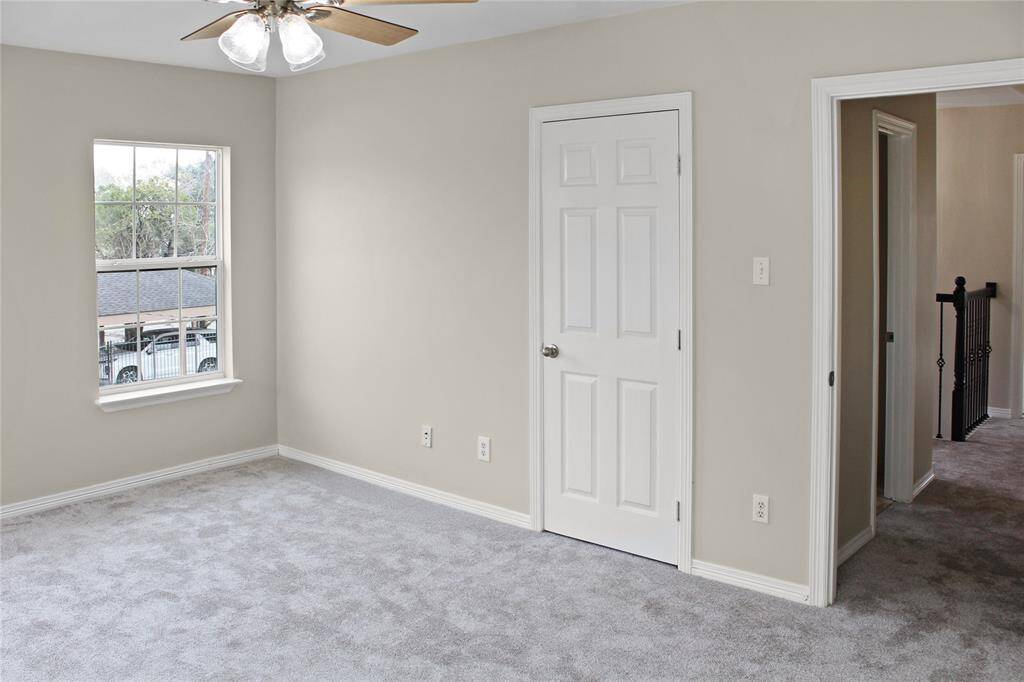 Bedroom #3 Spacious and bright bedroom with plush carpeting, fresh paint, and ample natural light from a large window. Ideal for relaxation or a cozy guest room.