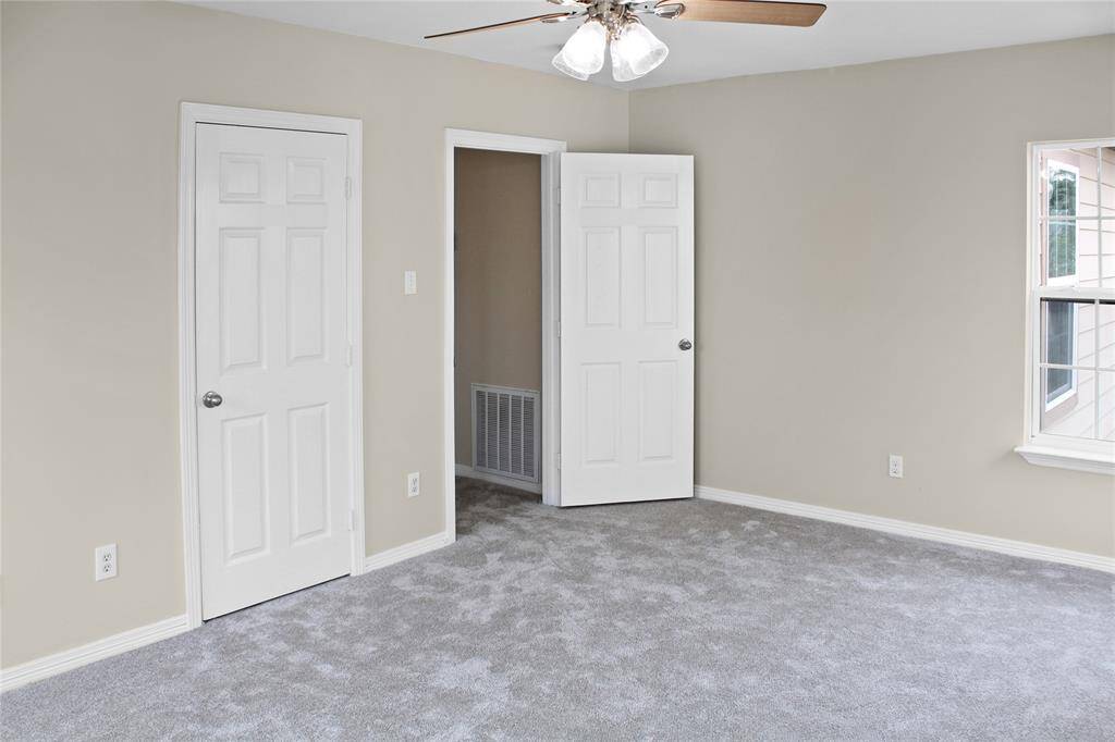 Spacious fourth bedroom featuring soft carpet, ample natural light, and a convenient closet.