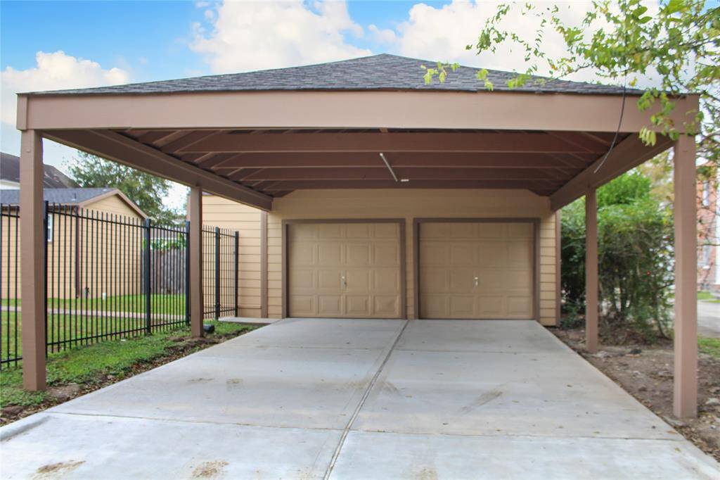 Freshly paved driveway leading to a spacious two-car garage.