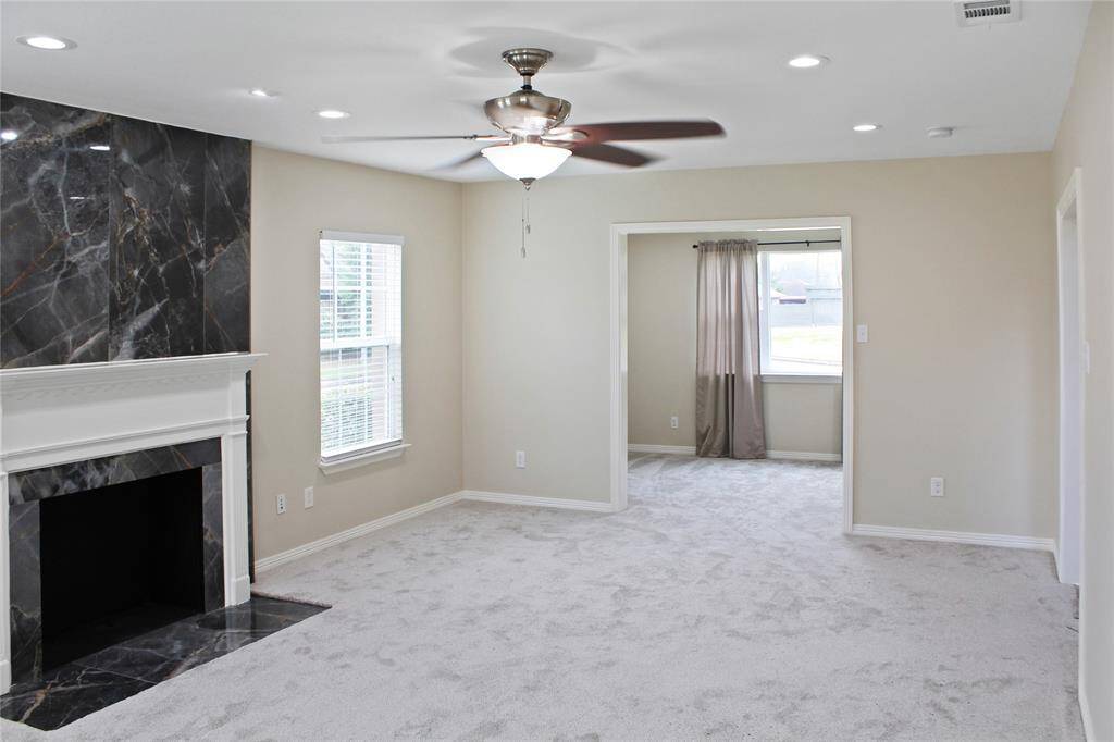 Spacious living room featuring an elegant faux fireplace, perfect for cozy gatherings.