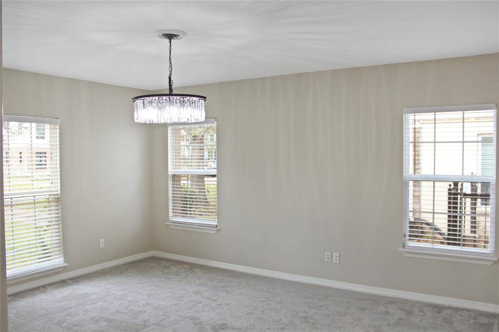 Cozy carpeted dining room with ample natural light, perfect for gatherings.