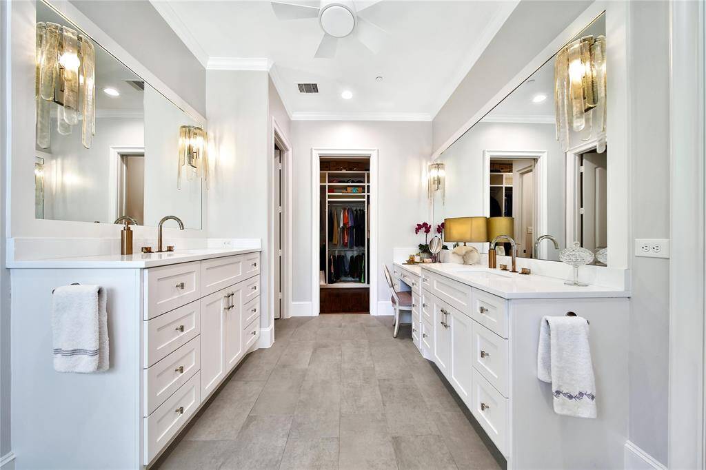 Expansive primary bathroom with updated sinks, countertops, hardware, commodes, faucets, lighting, shower finishes, and flooring.