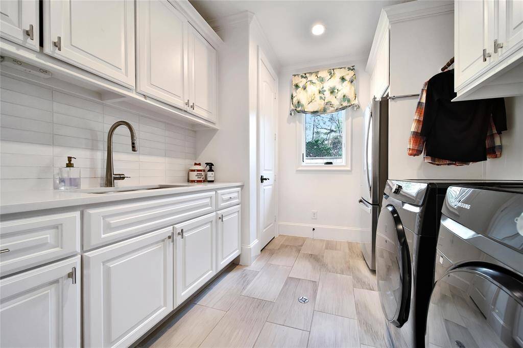 Expansive laundry room with sink and ample storage.