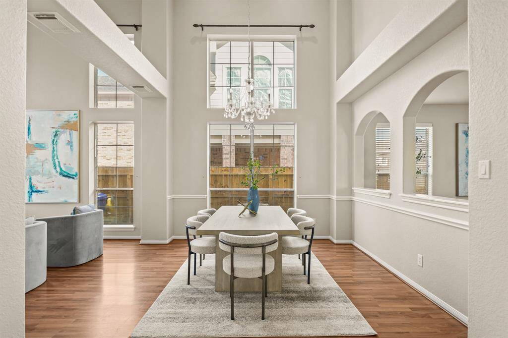 The open concept floor plan features combined formals. The formal dining room has a beautiful chandelier.
