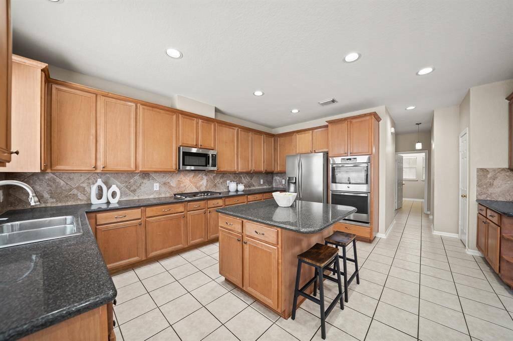 The kitchen has tons of cabinets, which provide great storage! Notice all the recessed lighting!