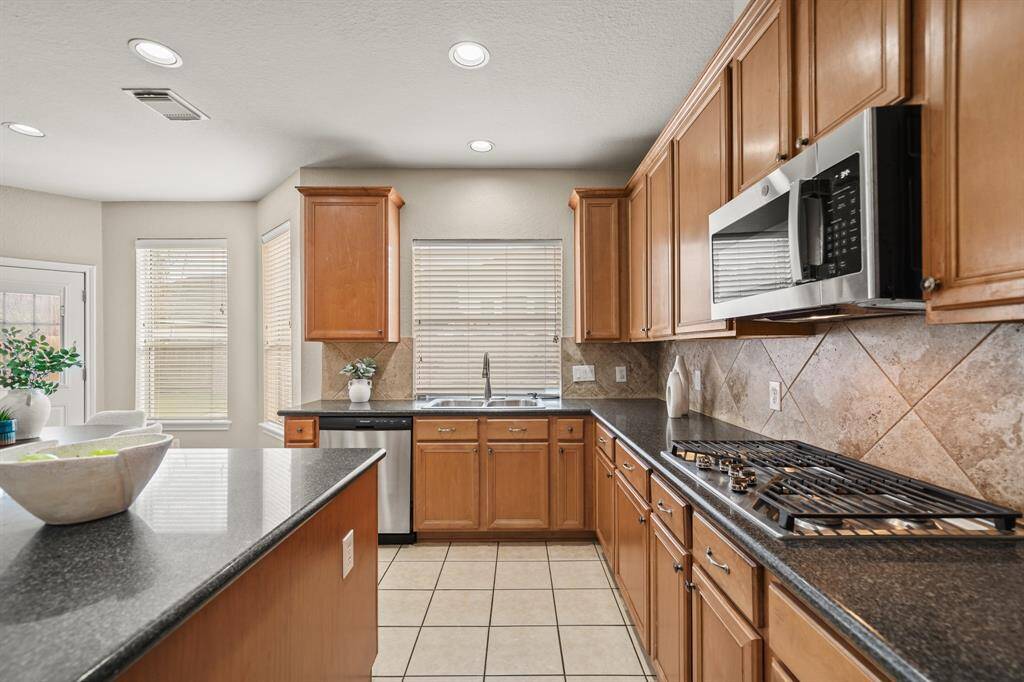 The stainless appliances include a gas stove top.
