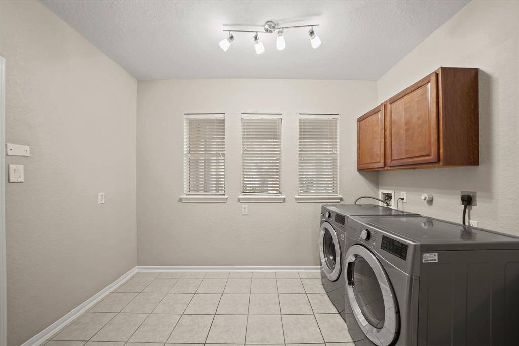 Wow! What a laundry room! The washer & dryer convey with the property. The cabinets make it easy to organize laundry supplies. There is plenty of room to have an additional refrigerator, freezer or add built-ins.