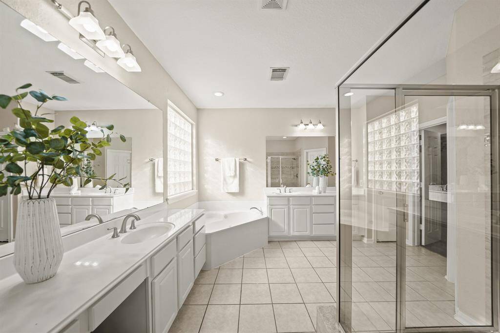The primary bath has an updated shower, faucets and lighting. With dual vanities, everyone has plenty of elbow room to get ready in the morning.