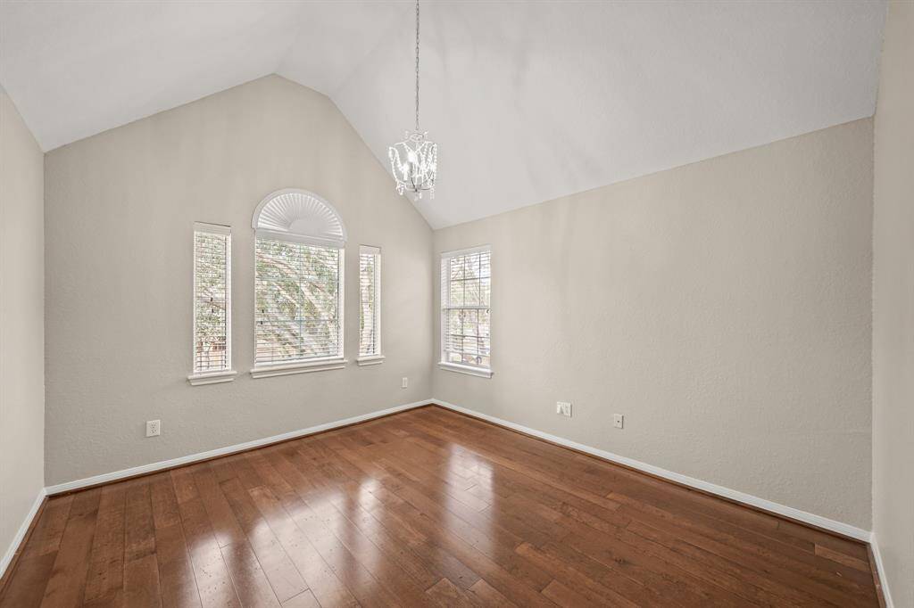Upstairs bedroom has a vaulted ceiling and a wall of windows.