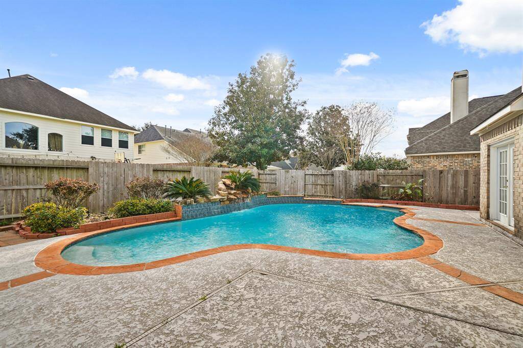 The pool has flagstone coping and a stone waterfall.